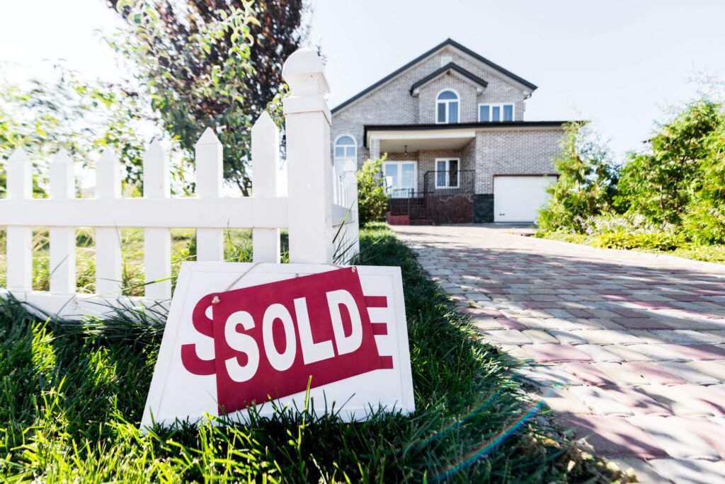 beautiful new house with sign sold standing on grass