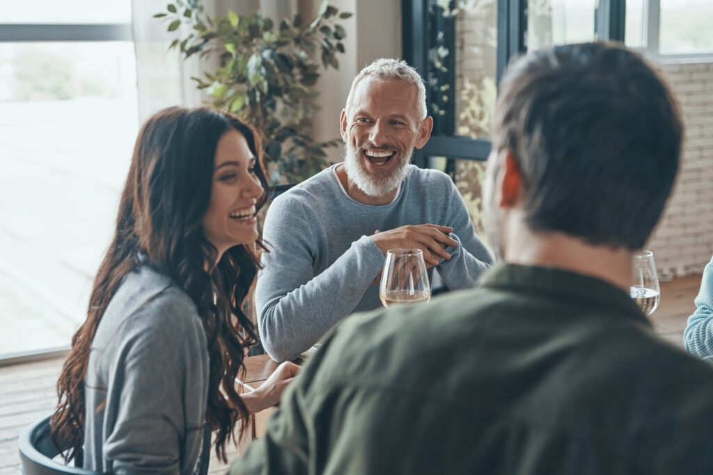 Happy family communicating and smiling while having dinner together