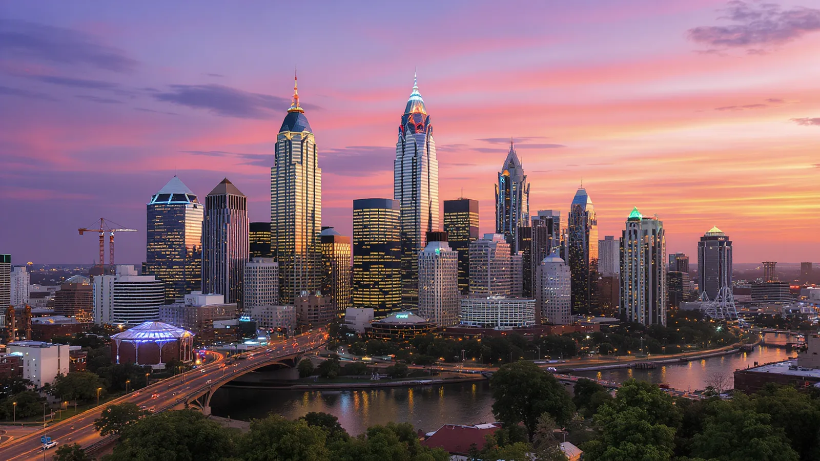 Modern Atlanta skyline at dusk with construction cranes and new residential towers against purple sky